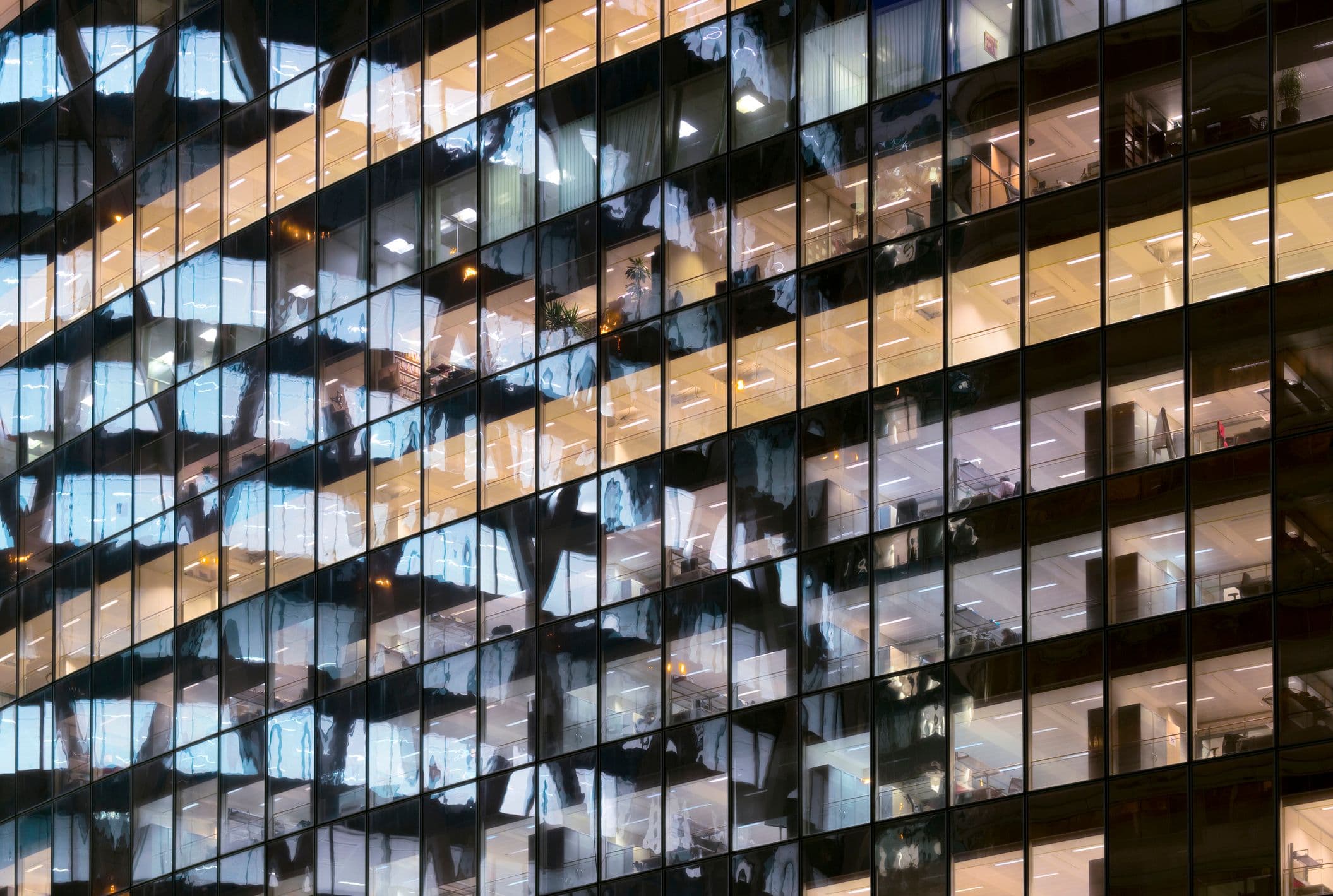A photo of glass office towers, with row after row of windows reflected in other windows.