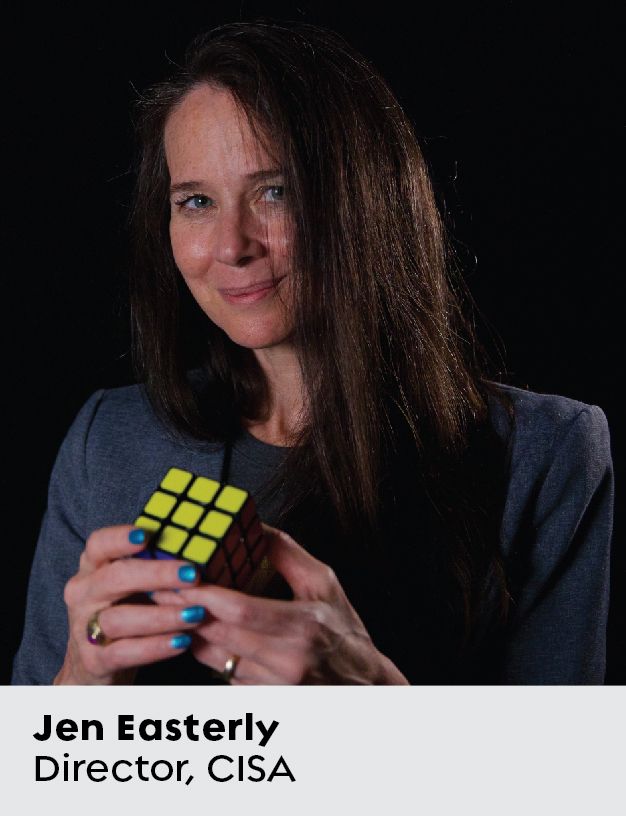 Headshot of woman in blue blazer holding a Rubik's cube