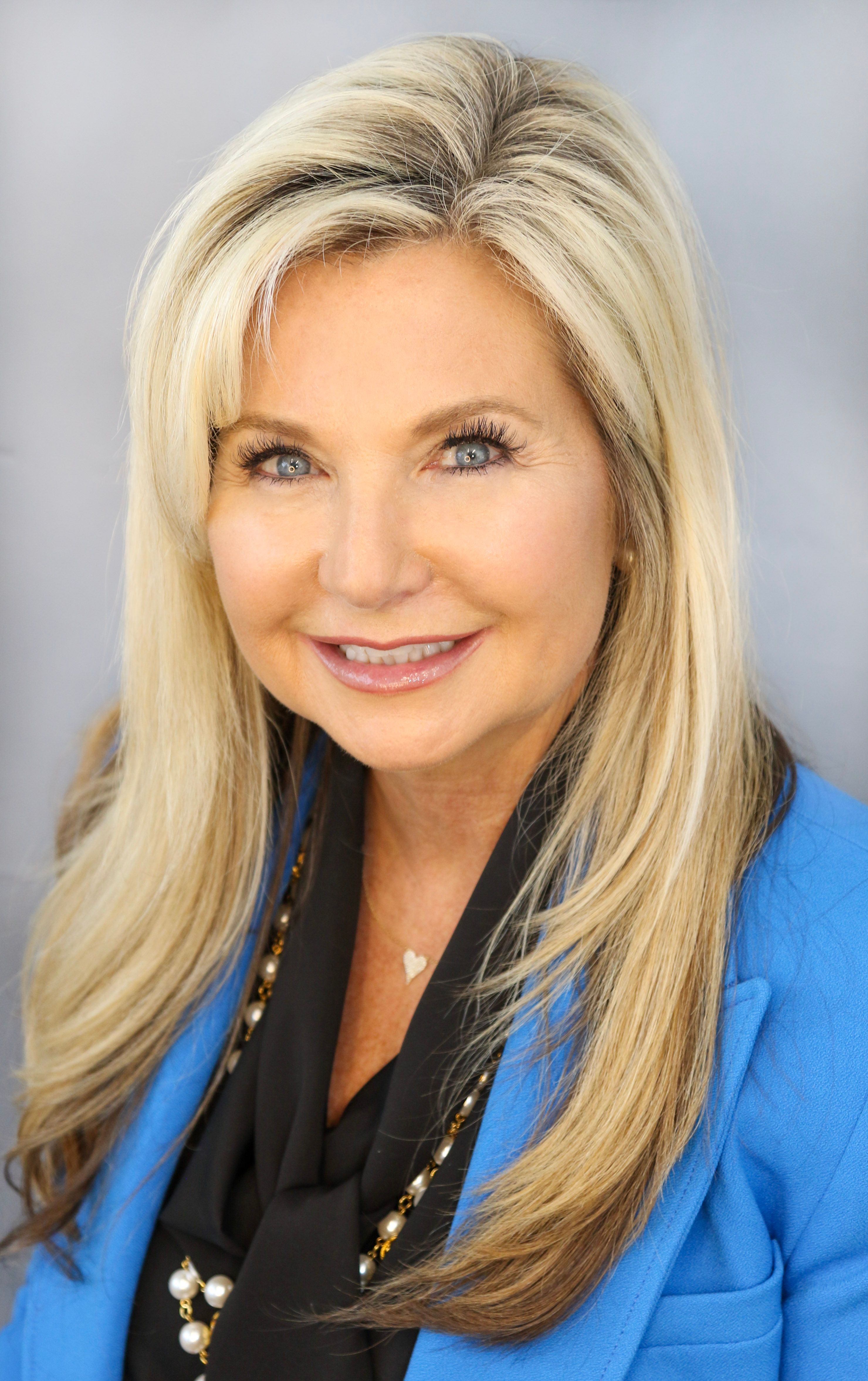 Professional headshot of woman with blonde hair in blue blazer