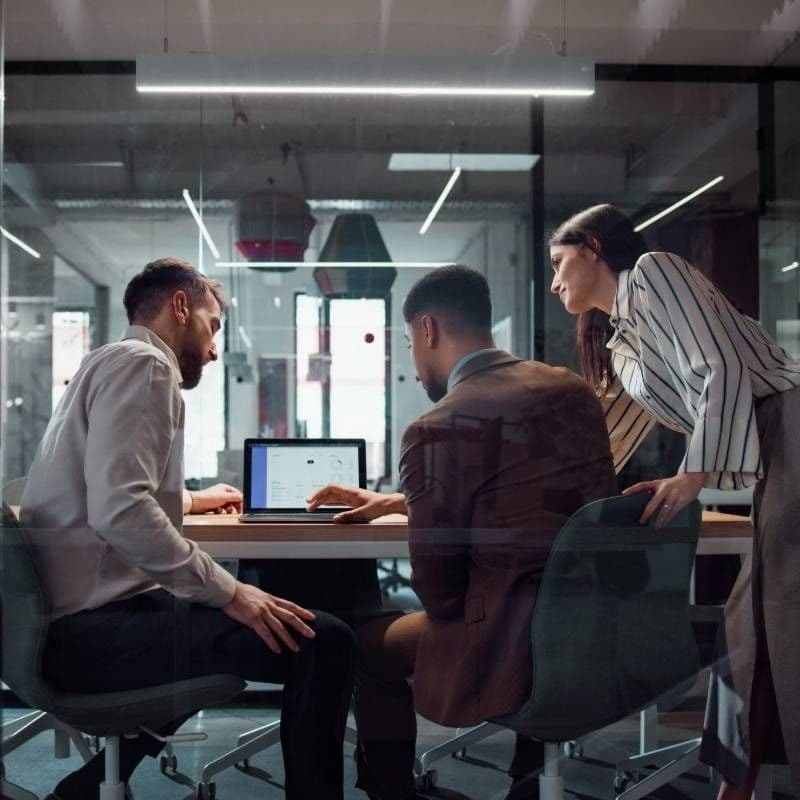 Image of group of professionals looking at laptop screen
