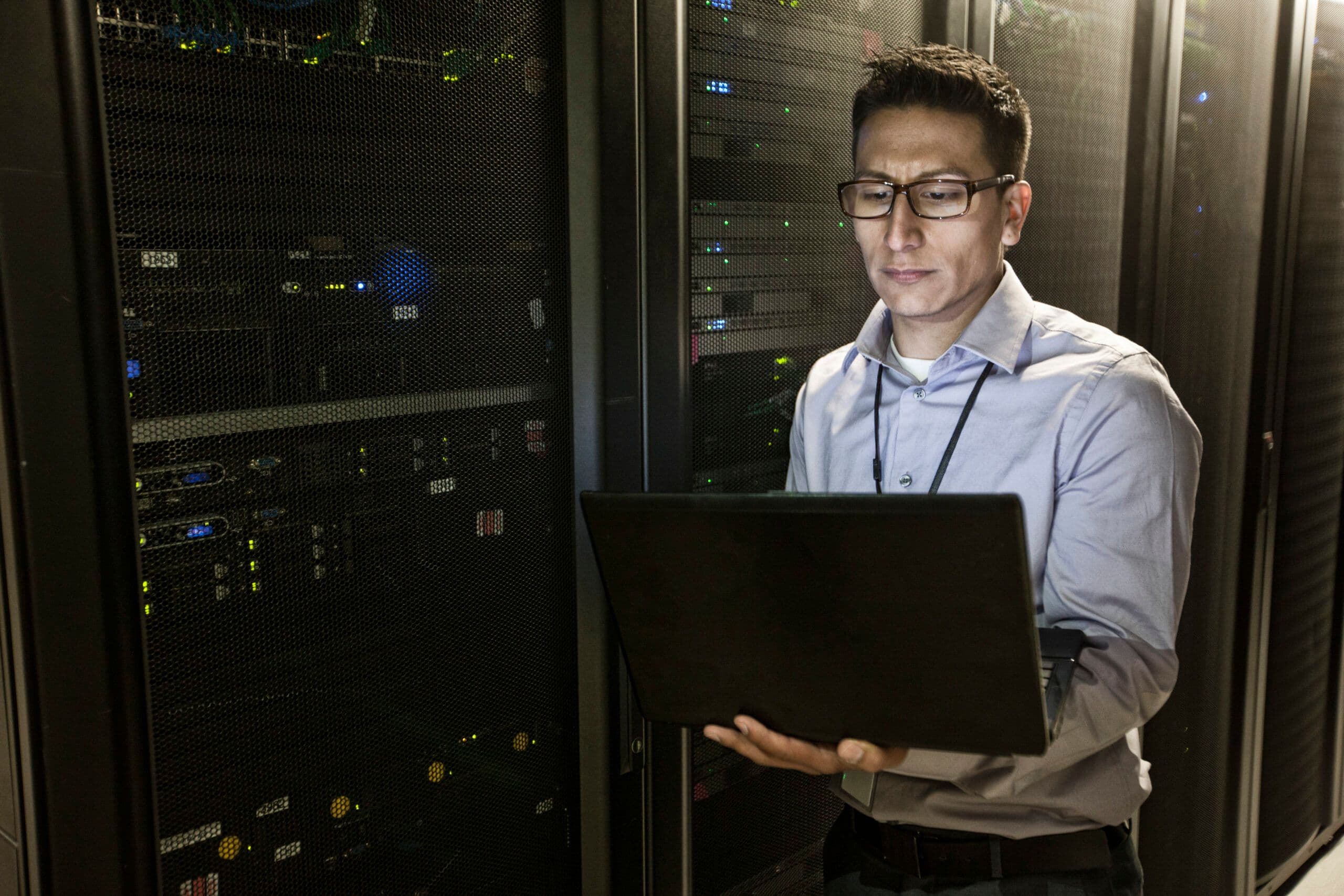 IT professional performing Linux patch management in a data center with server racks and networking equipment