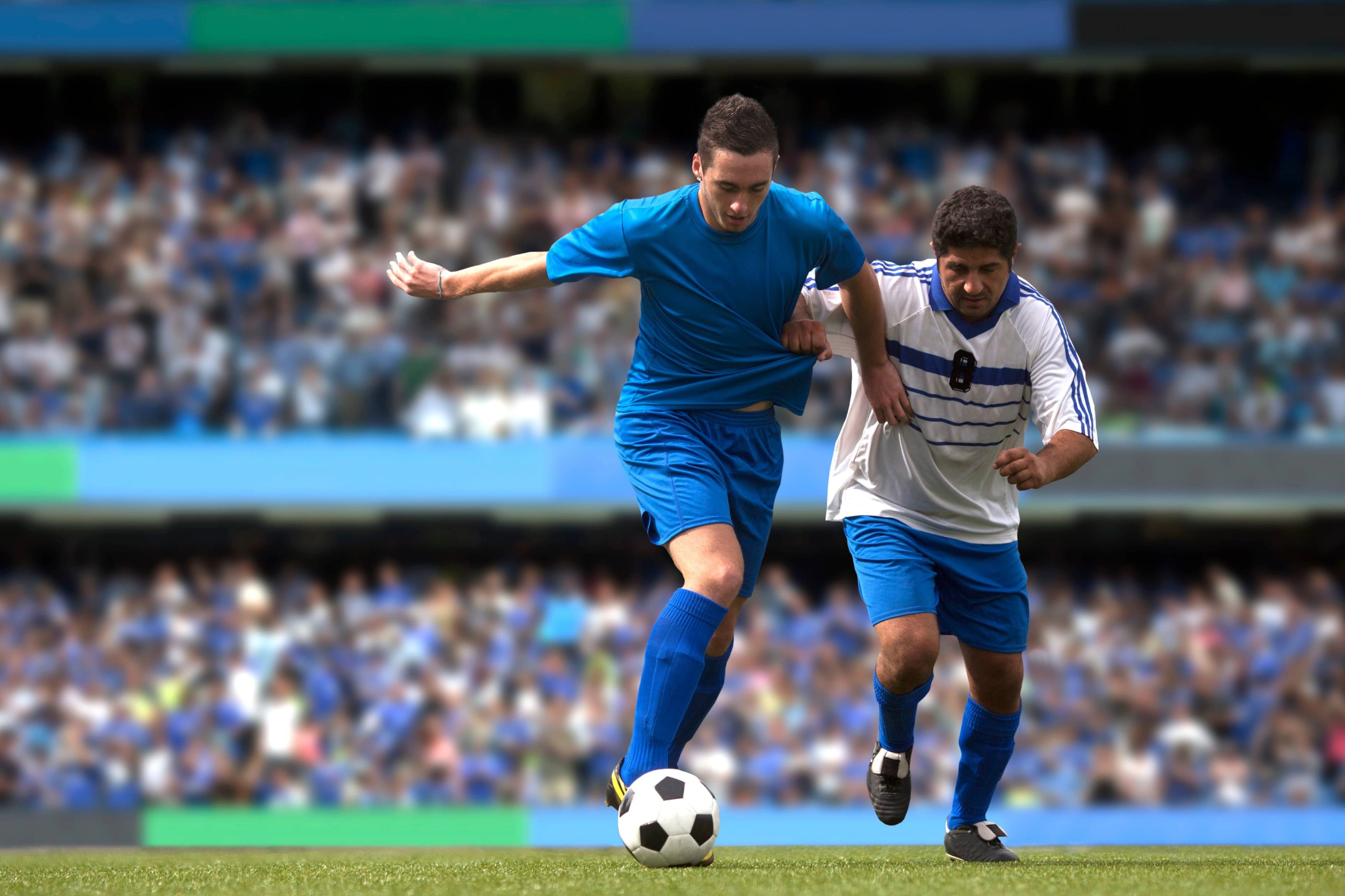Soccer players on field in large stadium with crowd