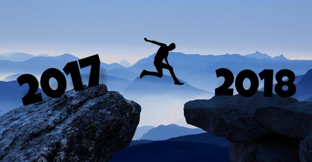 Silhouette of person jumping between rocks labeled 2017 and 2018