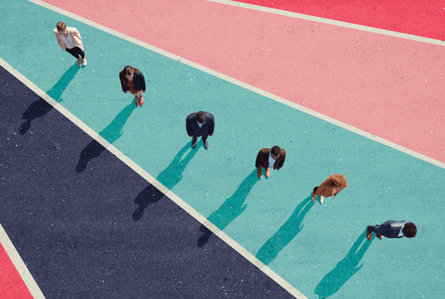 A photo of office workers, seen from above, standing on pavement painted in vivid stripes.