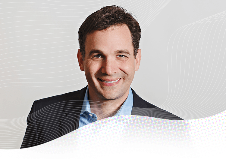 Professional headshot of man in blazer and light blue shirt