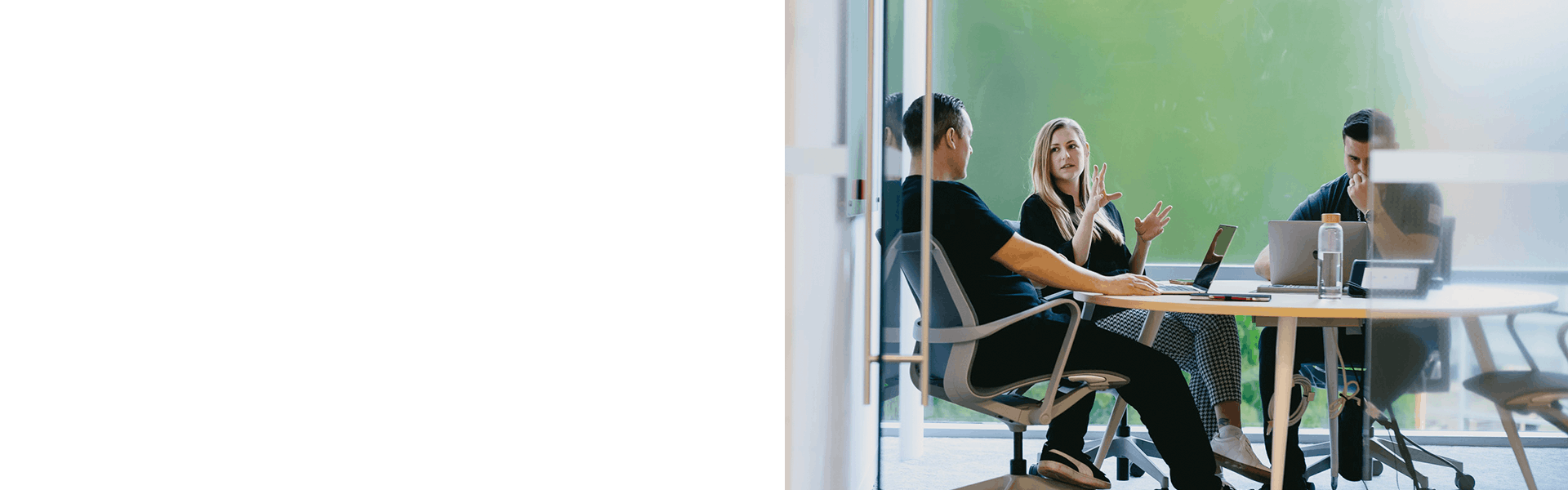 Team members collaborating in meeting room with nature views
