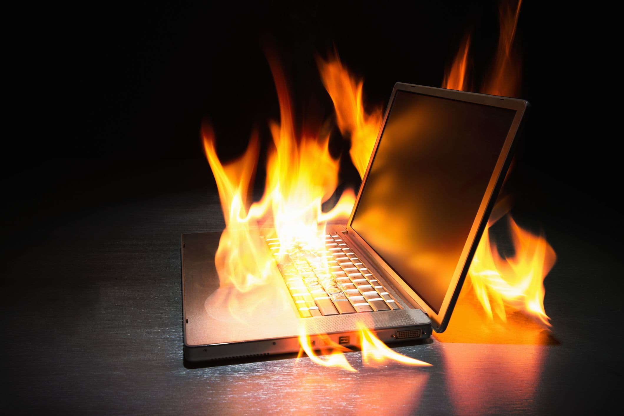 A photo of a laptop consumed by flames.