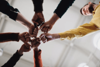 Diverse group of hands joined together in a circle from above