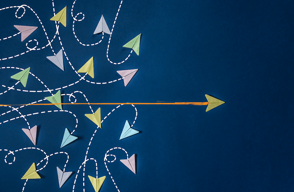 On a dark blue field, multicolor illustrated arrows swirl and veer while one arrow shoots straight across from left to right.