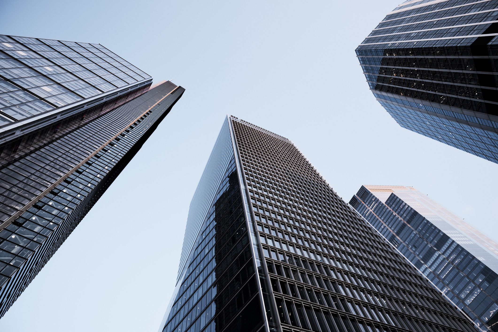 Photo of three skyscrapers seen from below and reaching for the sky.