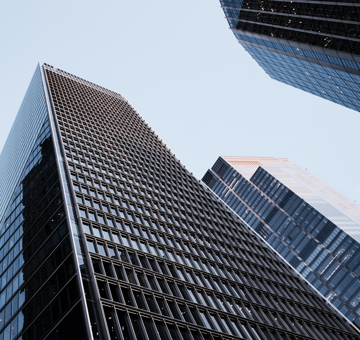 Photo of three skyscrapers seen from below and reaching for the sky.