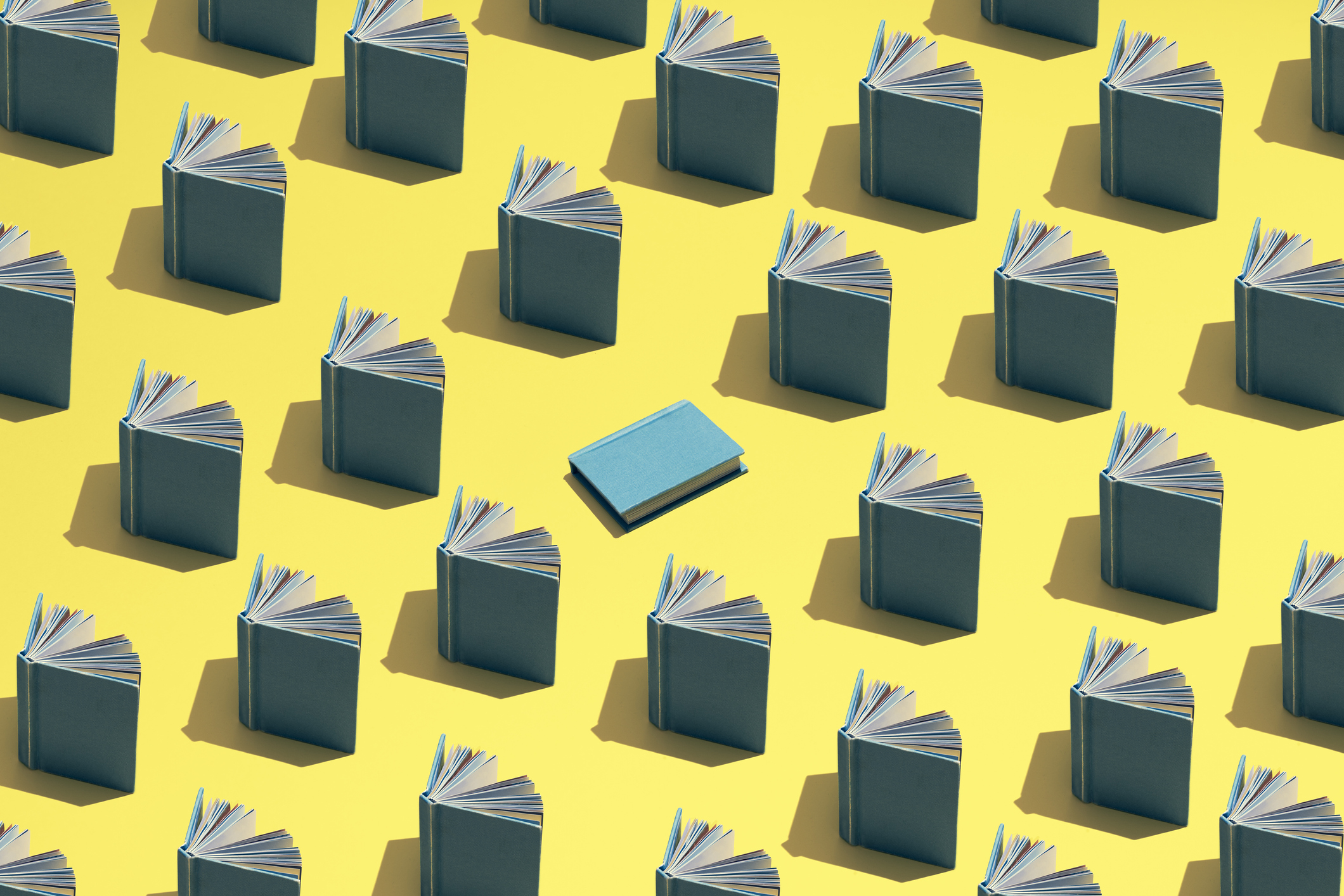 Blog featured image. An illustration of books propped open in rows against a yellow field and one blue book in center.