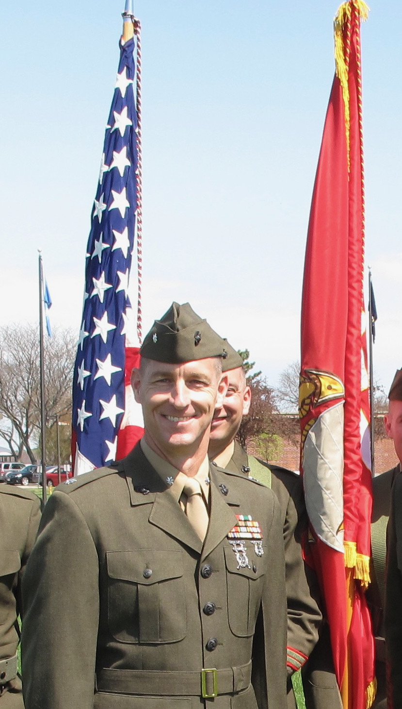 Kyle Dewar standing next to flags