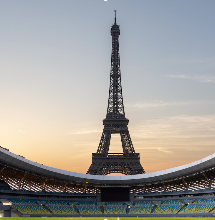 Seen from inside a stadium, the Eiffel Tower looms tall in the distance